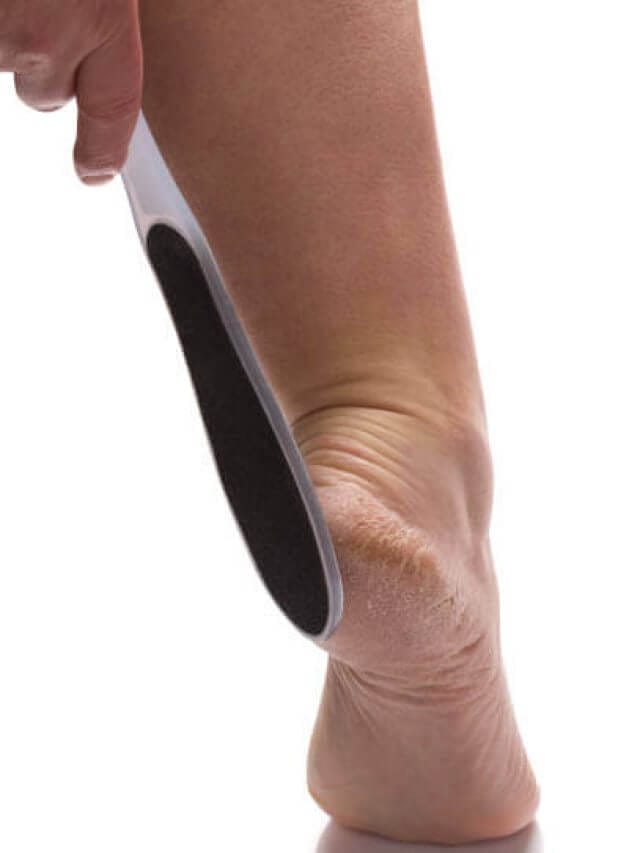 Female hand holding a foot file near her heel