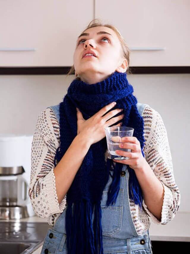 Young girl with quinsy taking medicine and gargling throat in kitchen