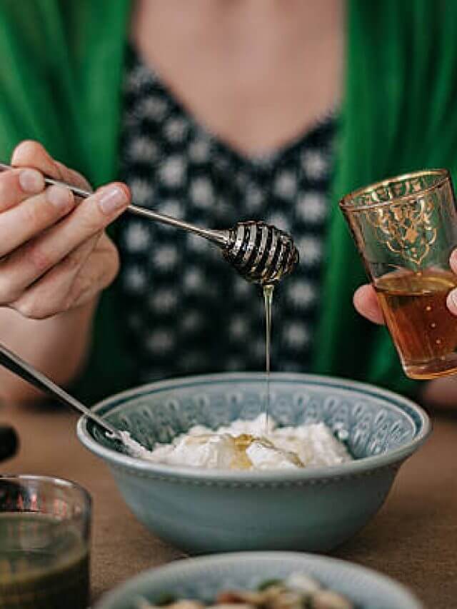Woman preparing breakfast yogurt and honey