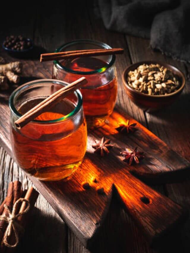 Tea or Chai tea on wooden board with spices as a cozy hot drink