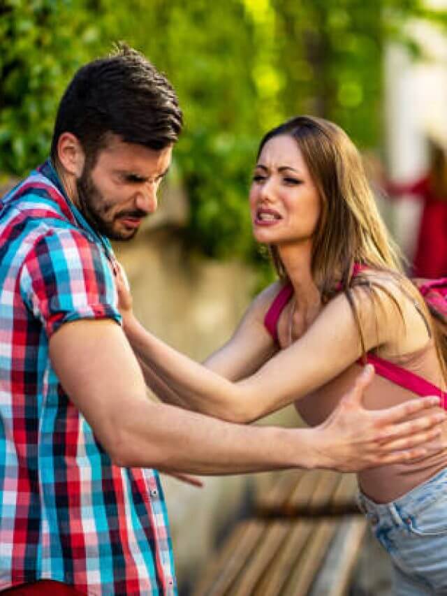 Angry man and woman quarreling on street.