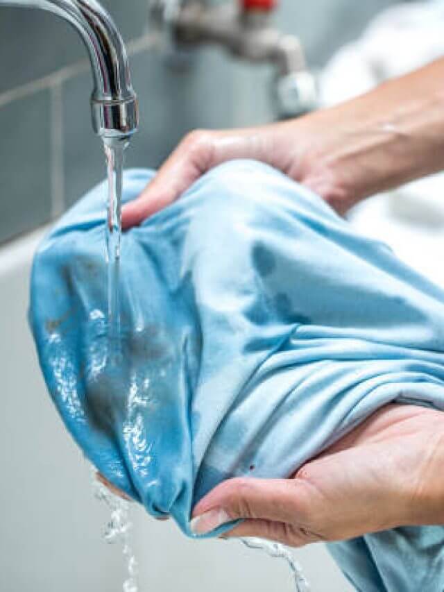 Woman Cleaning Stained Shirt in Bathroom Sink.