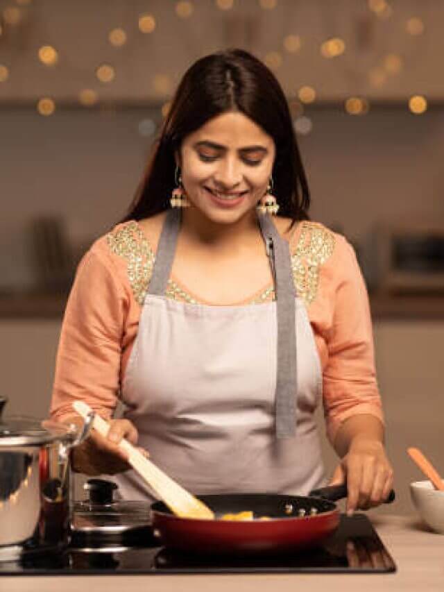 Portrait of a young woman cooking food in the kitchen