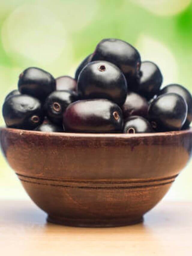 Jambolan plum or jambhul or jamun fruit, Java plum in a wooden bowl