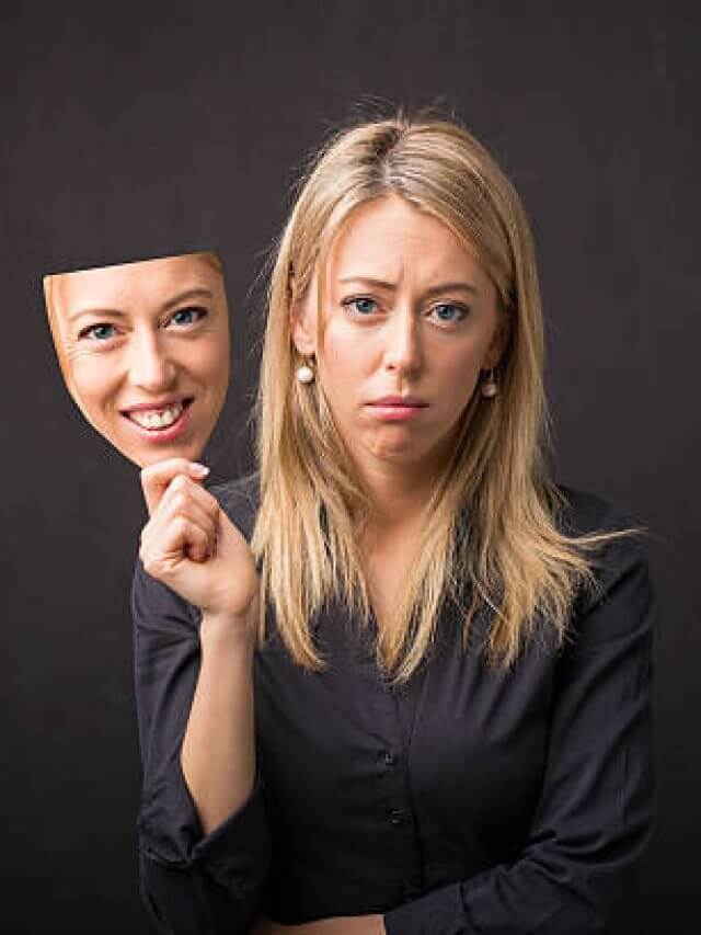 Woman holding mask of her happy face