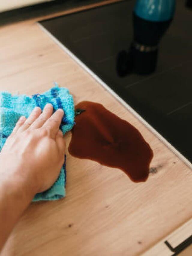 Hand cleaning a coffee stain on a kitchen counter
