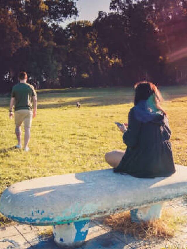 Breakup of a couple with guy leaving and sad girlfriend staying on the bench