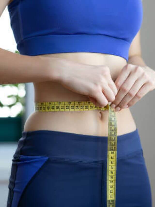 Unrecognizable young woman measuring her waist