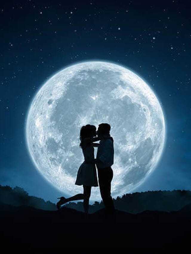 Silhouette of loving couple kissing against the full moon