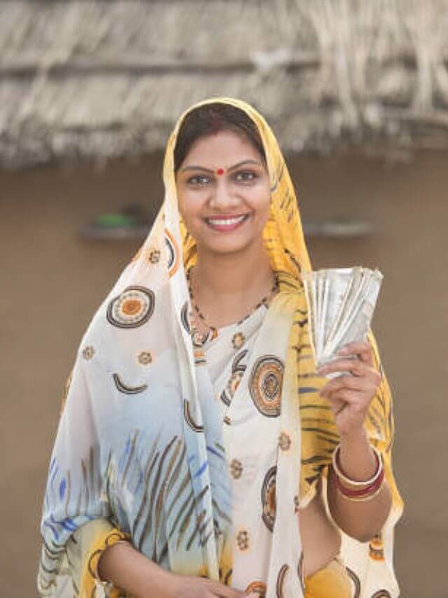 Successful woman holding Indian rupee notes and screaming at village